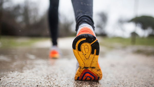 10 Dicas para atividade física no inverno - zoom em pés calçando tênis de corrida em terreno molhado