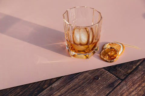 whiskey cocktail image with dried citrus on blush pink and timber vinyl photography backdrop