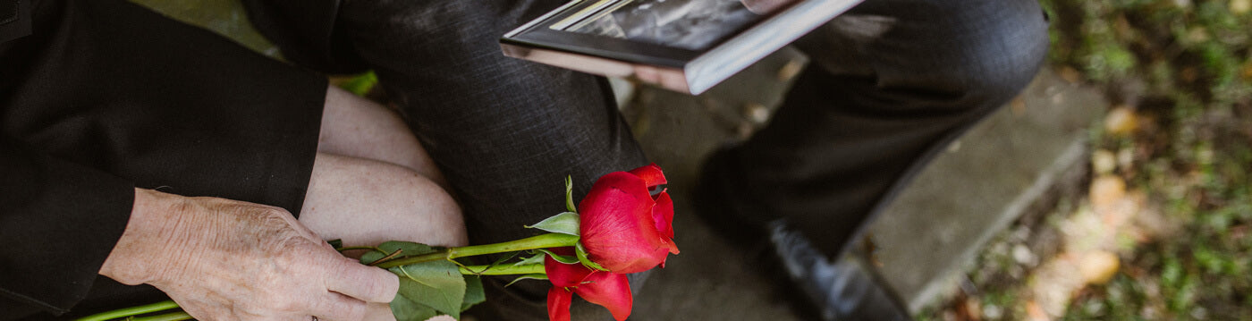 Cette image montre une rose rouge artificielle. Cette rose est déposée au cimetière