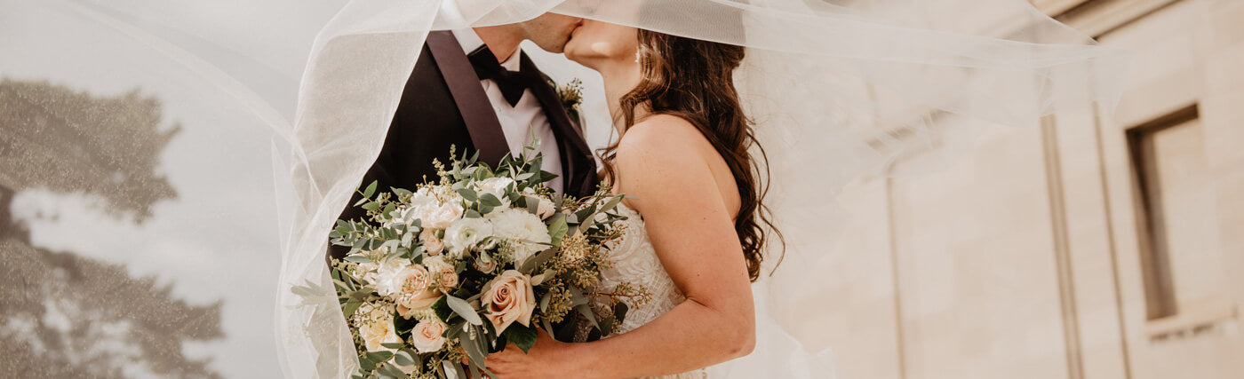 Cette image montre un couple de marié avec un bouquet de fleurs dans les mains