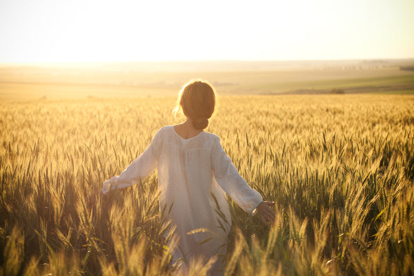 lady walking towards future through wheat field