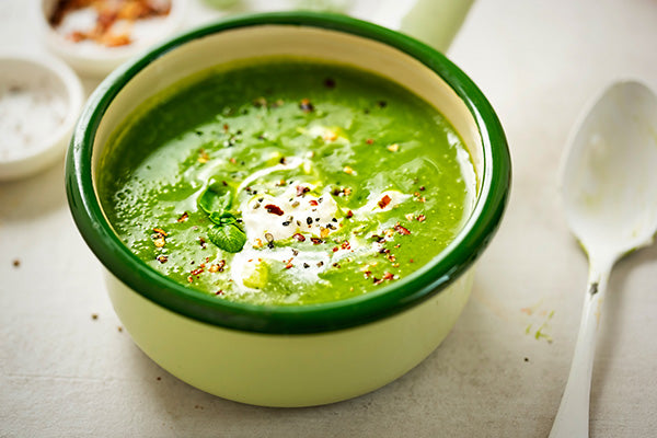 Zucchini and mint soup is a bowl full of green goodness steaming with a dollop of creme fraiche ready to eat.
