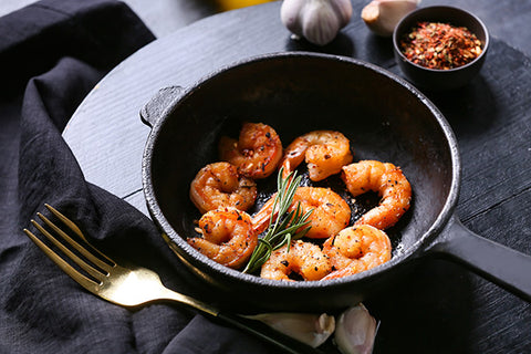 Black garlic butter and prawns in a wok ready to eat