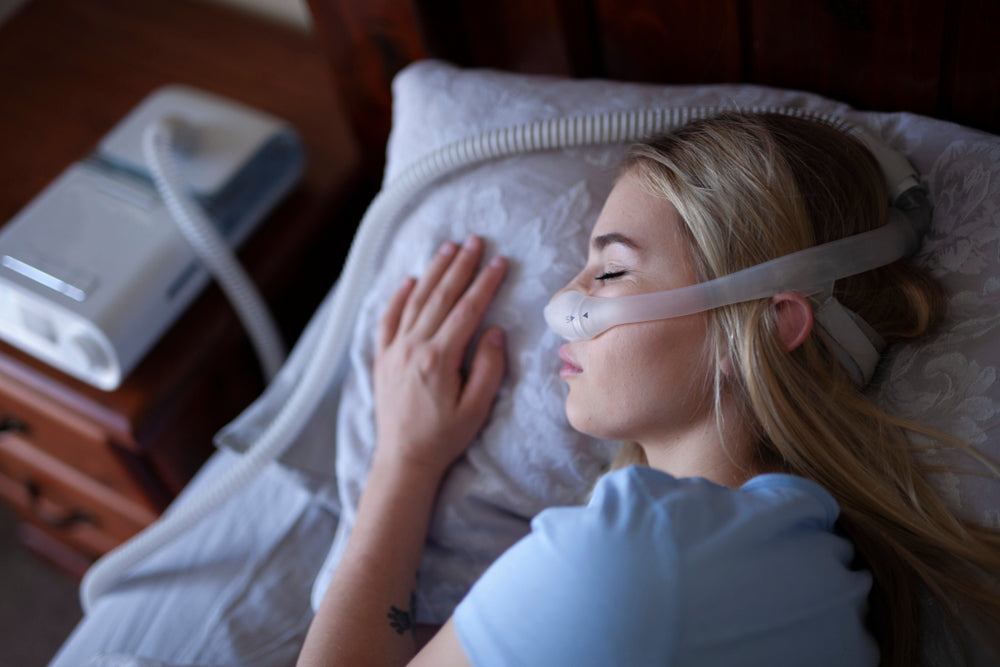 Woman sleeping in a relaxing space with her CPAP machine - CPAP Depot