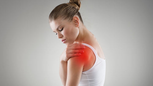 אישה סובלת מכאבים בכתף שמאל