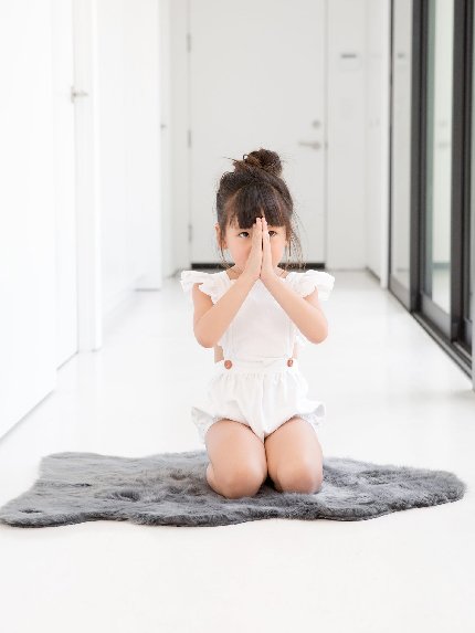 Toddler sitting on Luxe Loft™ Lamby gray faux fur rug