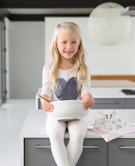 Toddler sitting on counter next to giraffe lovey