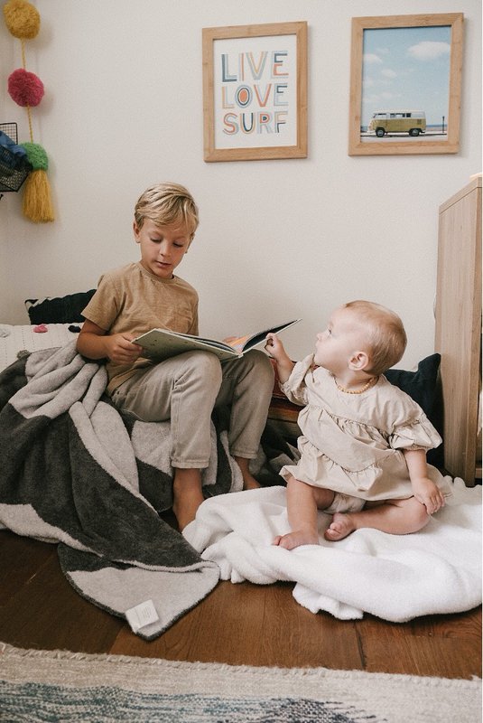 Baby and brother with their baby blankets