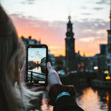 Téléphone prenant une photo d'un coucher de soleil en ville 