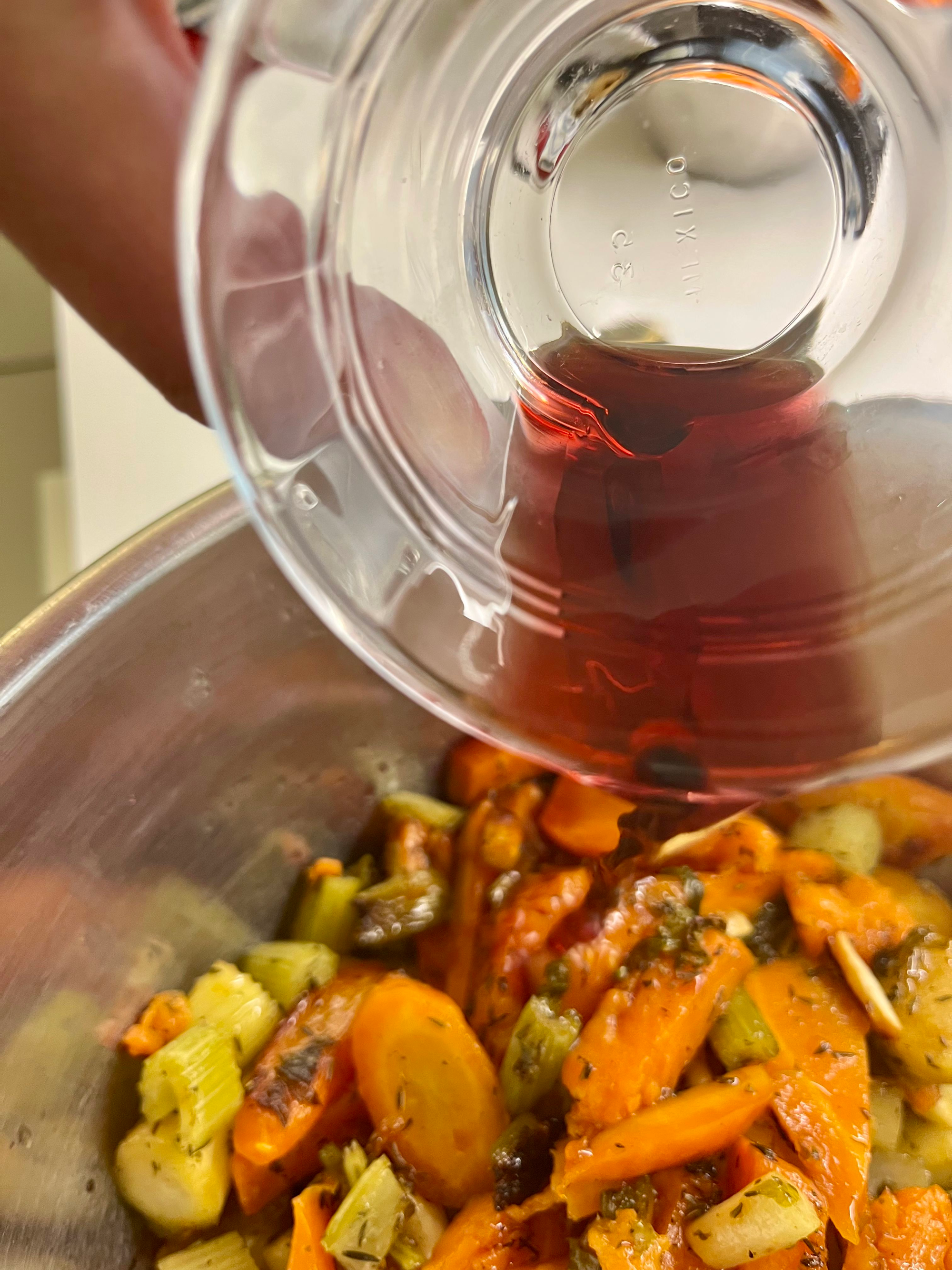 Pouring sherry on vegetables.