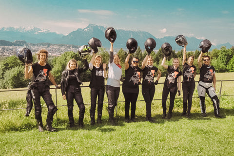 a group of femme riders at maria plain with salzburg in the back