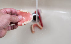 dentures being washed in a sink