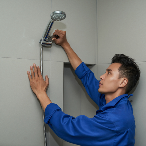 person installing a shower head holder