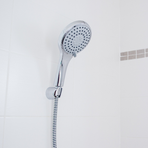 chrome shower head in a shower head holder