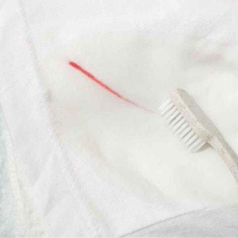 Using a toothbrush to remove pen ink stains from clothes
