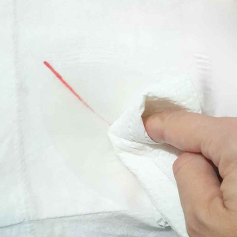Removing a pen ink stain from clothing by blotting with alcohol