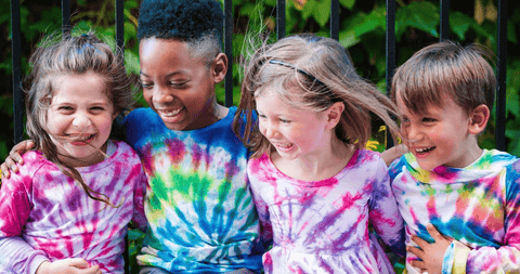 Four happy kids wearing colourful tie-dye Tshirts