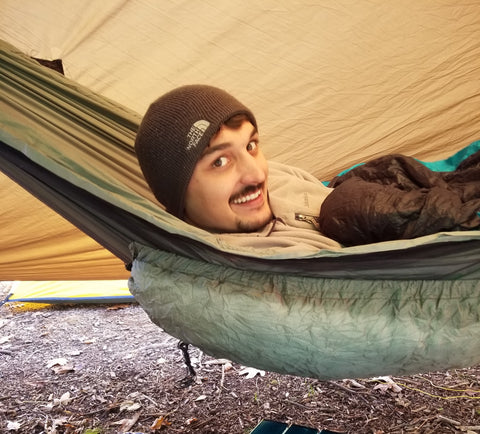 person in hammock with underquilt and sleeping bag top quilt