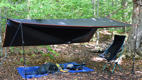 Hammock and tarp setup with a chair to sit in