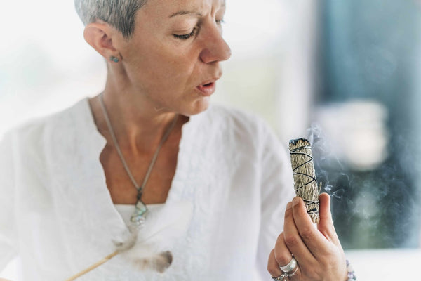 Nature-based practices, a woman burning sage for blessings.