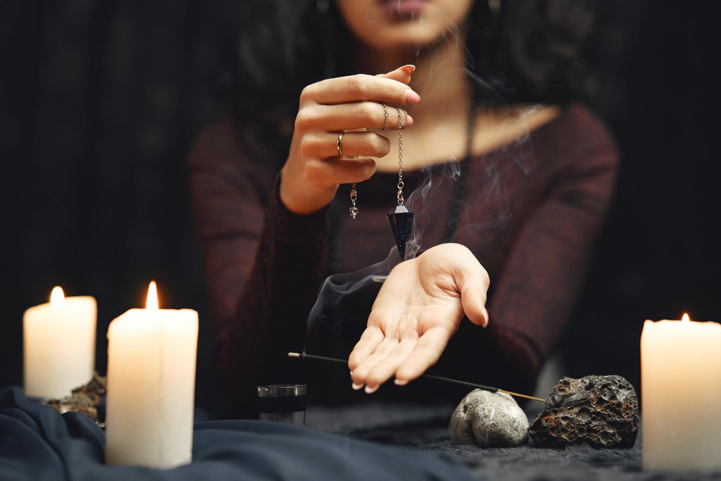 Participating in seances, a woman using a pendulum and candles.