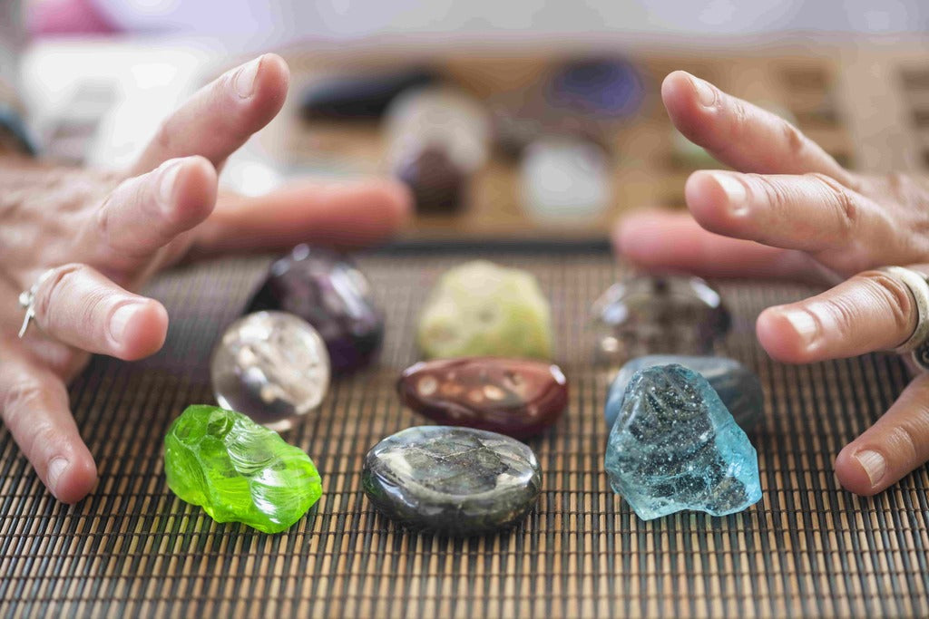 History of crystal reading, hands near various healing crystals.