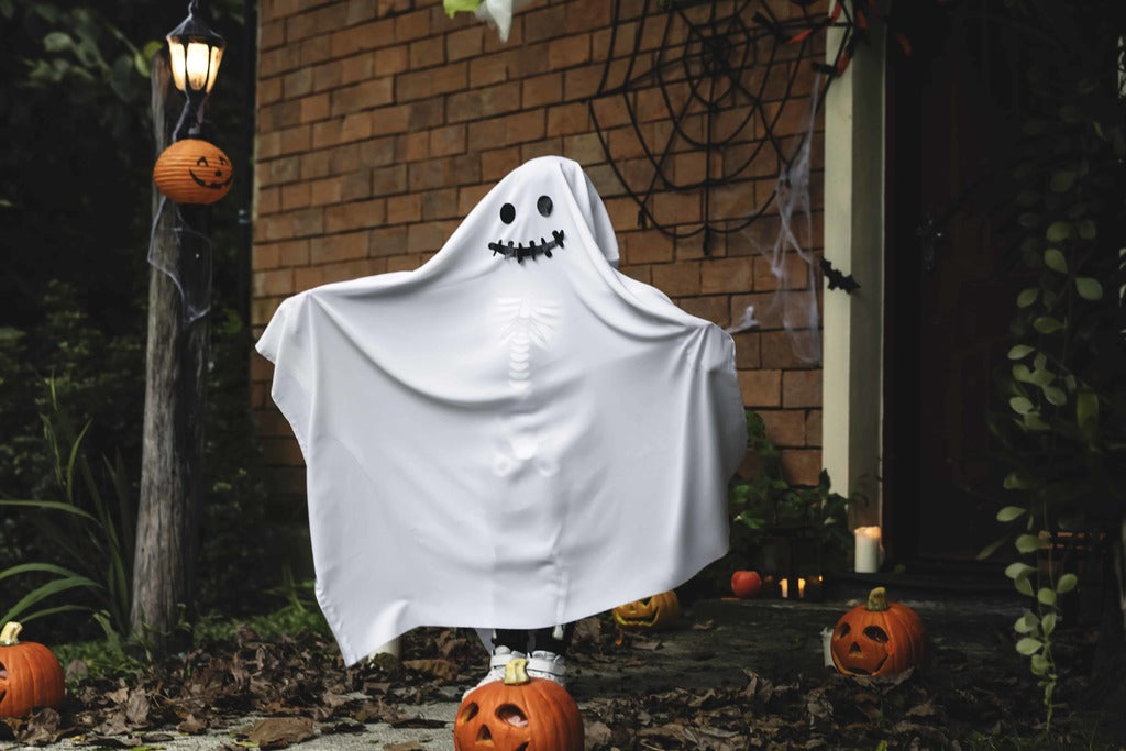 Halloween wardrobe, kid dressed in a ghost costume.