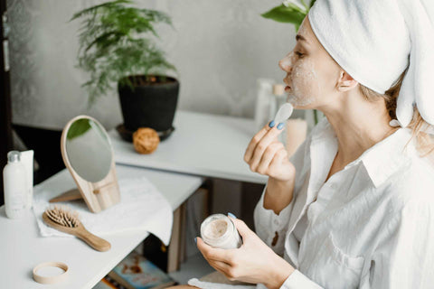 A woman applying self care products 