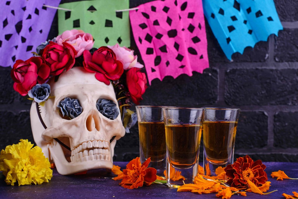 Halloween celebrations, a skull with flowers near shots of tequila.