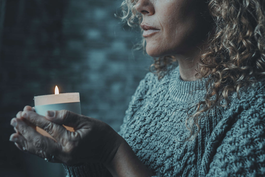 Participating in seances, a woman holding a candle.
