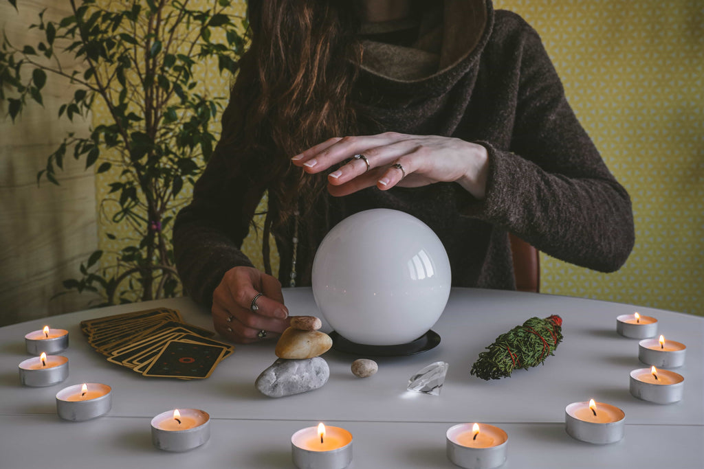 Witchy Halloween, a woman using a crystal ball and tarot cards.