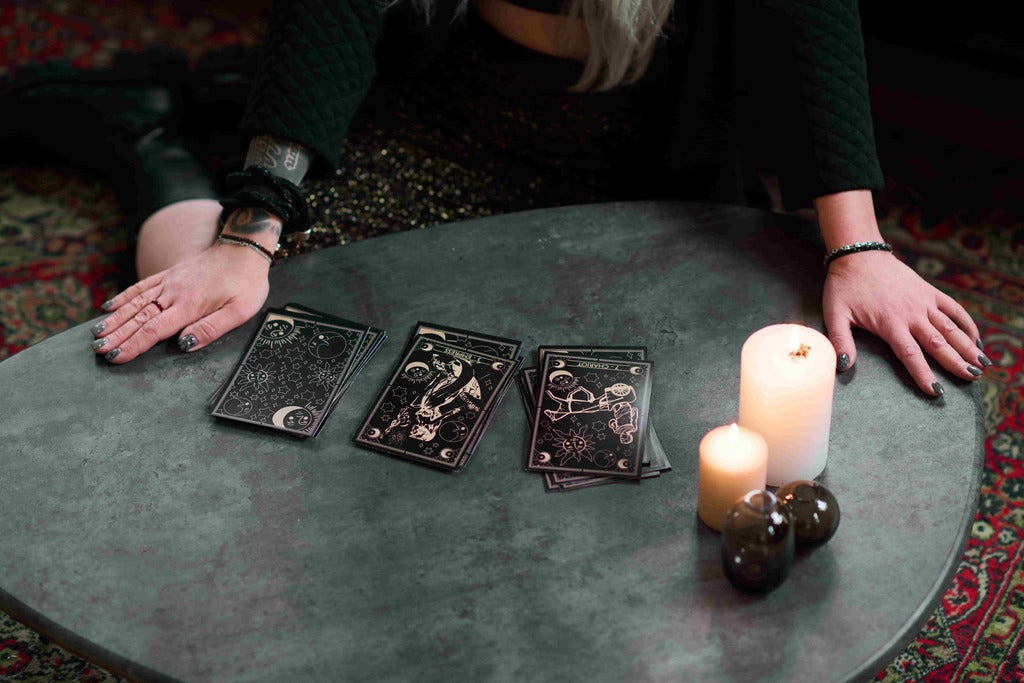 Halloween for adults, woman with tarot cards and candles.