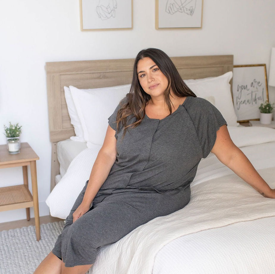 Woman sitting on bed in a Universal Labor and Delivery gown