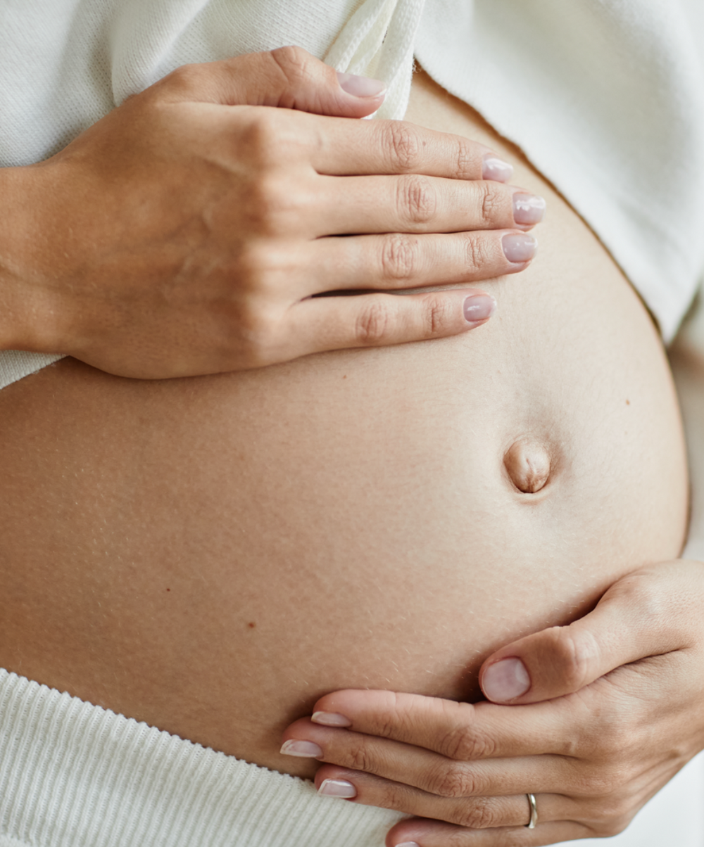Беременные женщины. Беременный живот. Беременный живот на белом фоне.