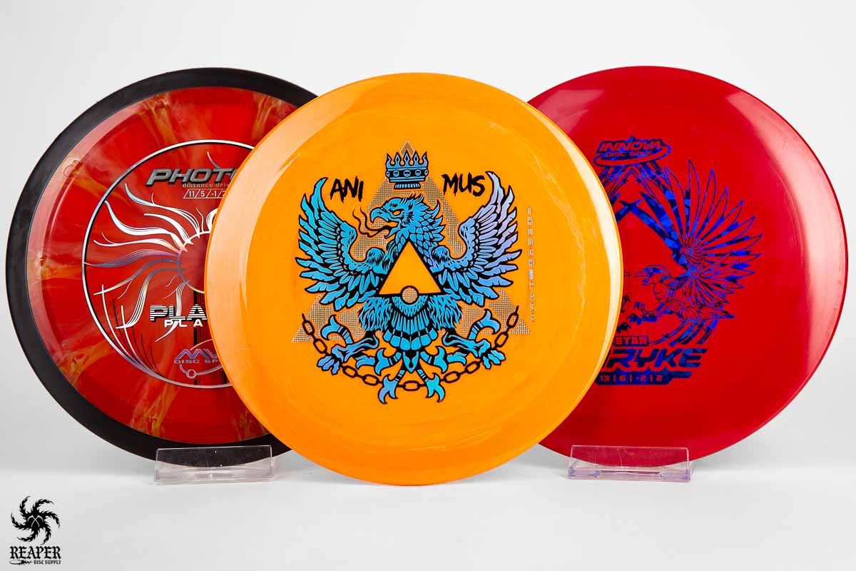 Three forehand distance driver disc golf discs with studio lighting