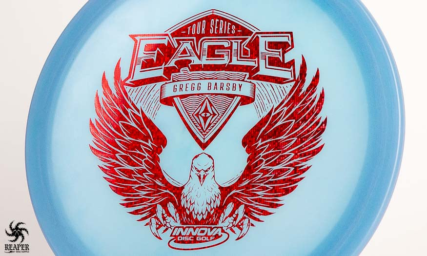 A blue Innova Eagle Gregg Barsby Tour Series disc with a red stamp