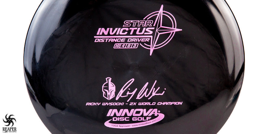 A black Innova Invictus distance driver disc with pink stamp