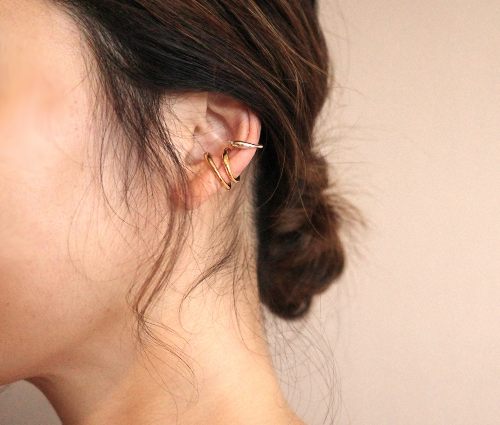 q paris(キューパリ) キューパリのゴールドとシルバーのイヤーカフをあわせている女性の耳