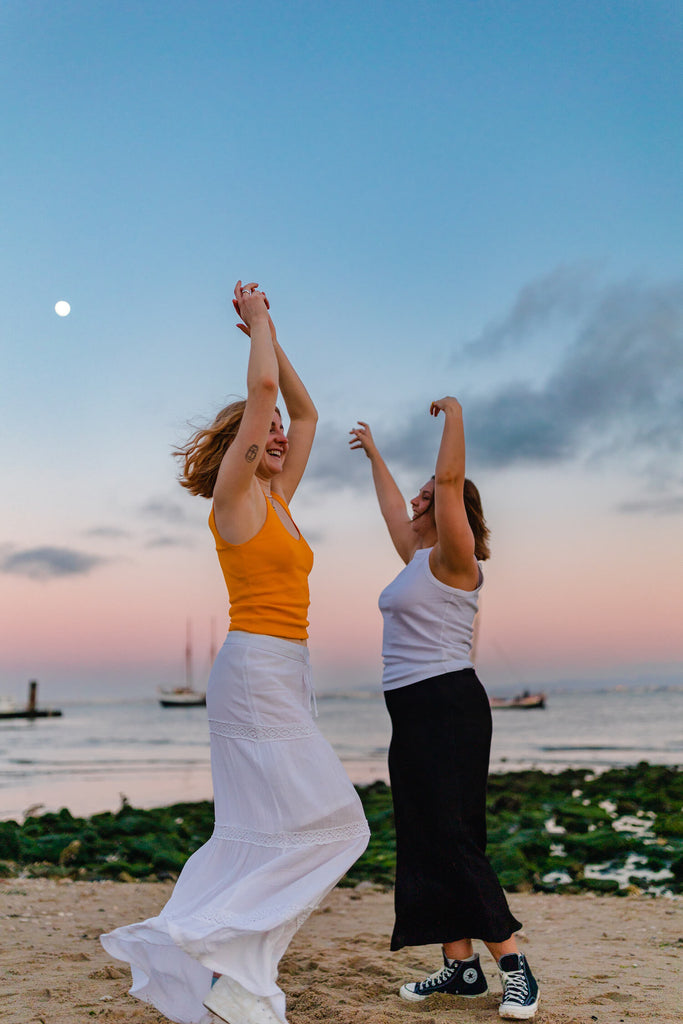 Interview with Rosie Lugg @rambosphotos. Two girls dance at the beach at sunset.