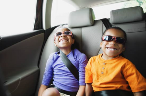 toddlers in the car smiling while listening to an audiobook