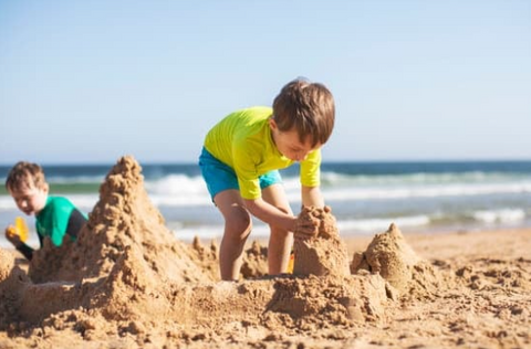 building sand castle at the beach is one of the outdoor activities to keep toddlers and kids busy