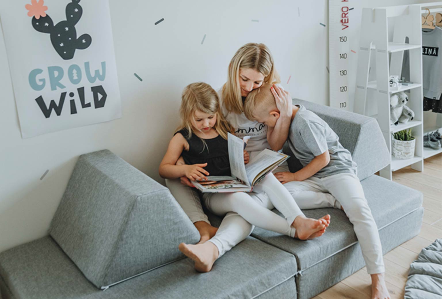 Mother and two children relaxing, reading a book