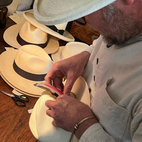 Oska putting a flourish in a Panama hat