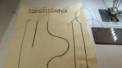 A sample of four kinds of topstitching in black thread on plain muslin - straight stitch, triple stitch, double-thread stitch and using topstitching thread.
