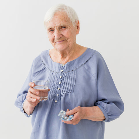 A senior lady with a multivitamin pill.