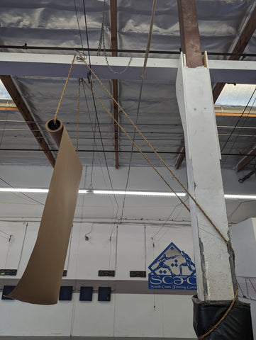 Paper hanging from ropes tied to ceiling of fencing school