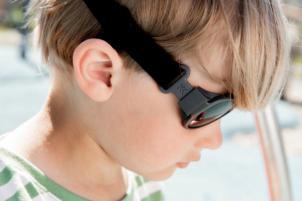Pojke bär svarta Mokki Click & Change-solglasögon