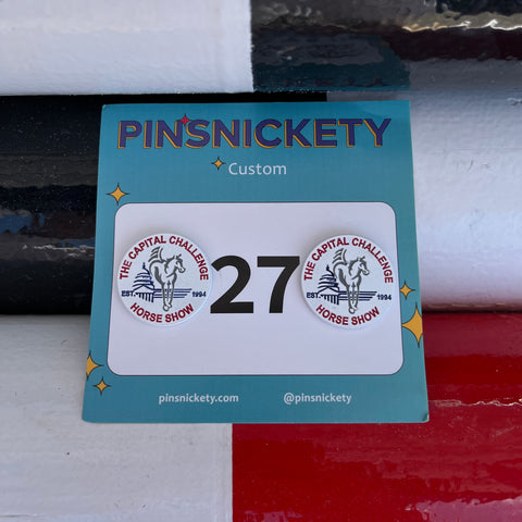Pinsnickety Custom Capital Challenge Horse Show number pins on a jump