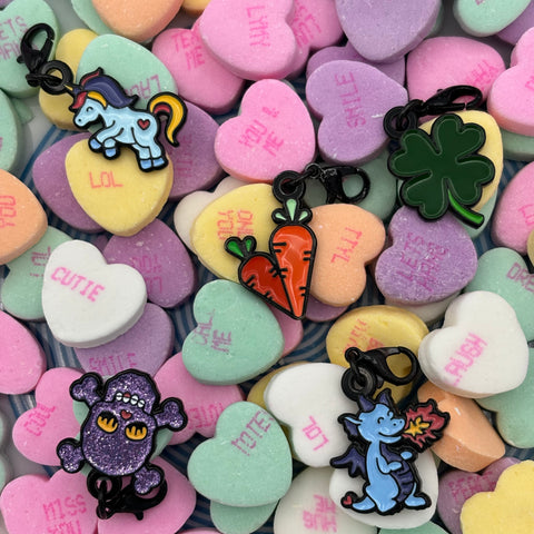 pinsnickety braid and bridle charms on a plate of candy conversation hearts for valentine's day