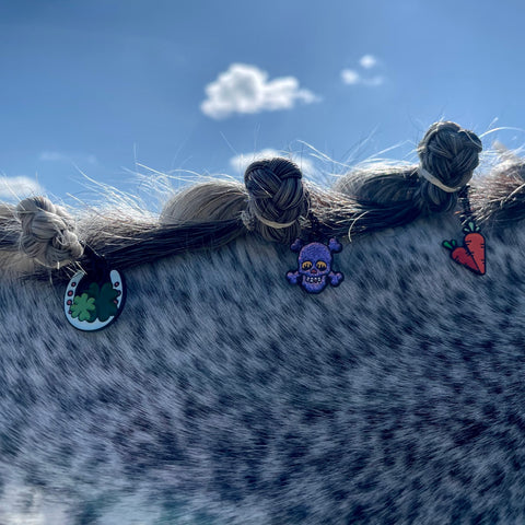 pinsnickety horseshoe, skull, and carrots charms in a grey horse's braided mane